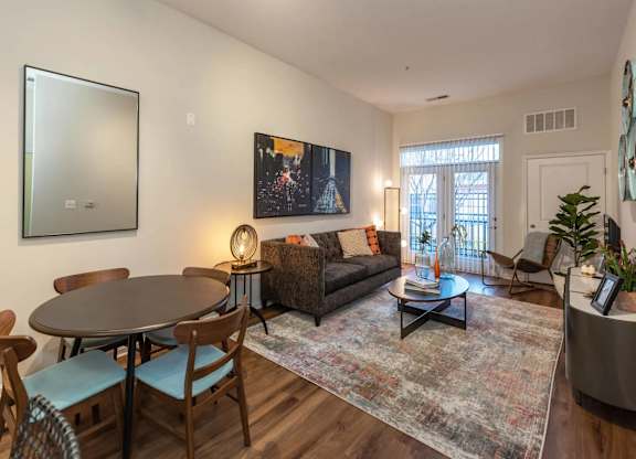A living room with a couch, a table, and a painting on the wall.
