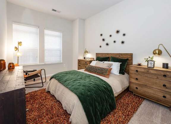 A bedroom with a bed, a dresser, and a window.