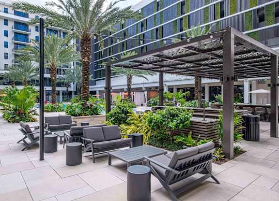 A patio with a table and chairs and a palm tree.