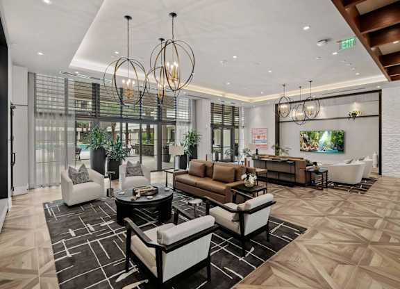 A modern living room with a black and white patterned rug and a variety of seating options.