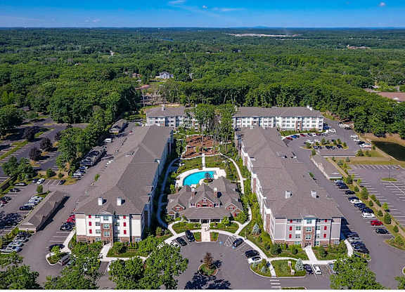An aerial view of a resort with a swimming pool and a parking lot.