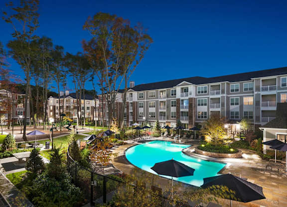 A large apartment complex with a pool in the foreground.