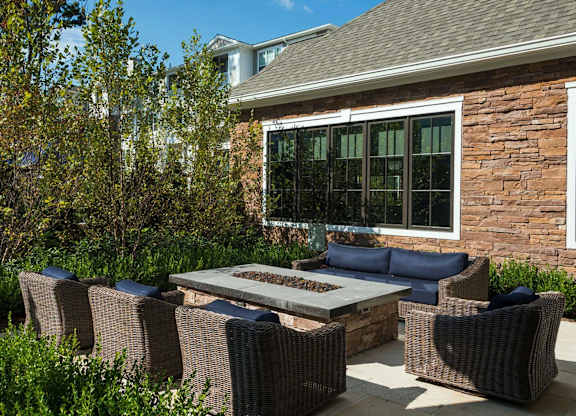 A patio with a table and chairs in front of a house.