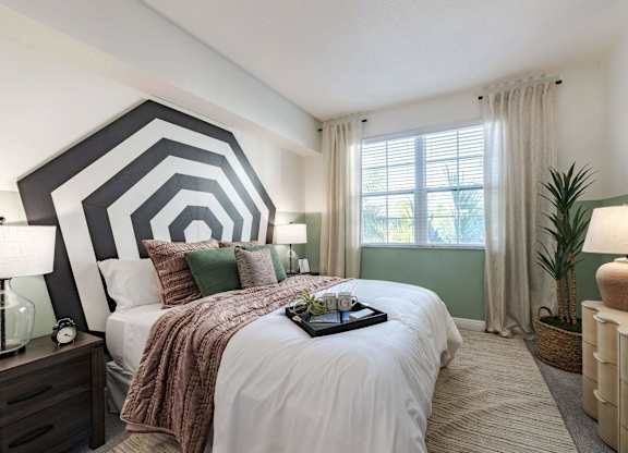 A bedroom with a large bed and a tray of flowers on it.