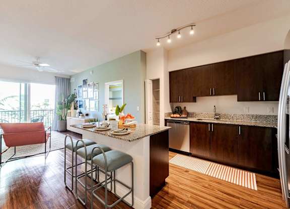 A modern kitchen with a bar stool and a dining table.
