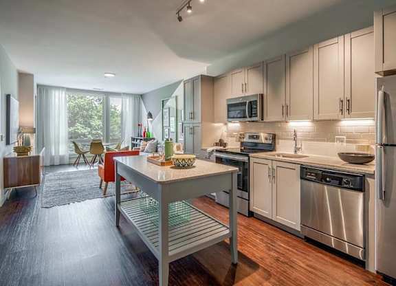 A modern kitchen with stainless steel appliances and a central island.