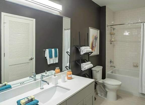 A bathroom with a white sink and a white toilet.
