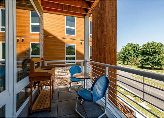 A balcony with a blue chair and a table.