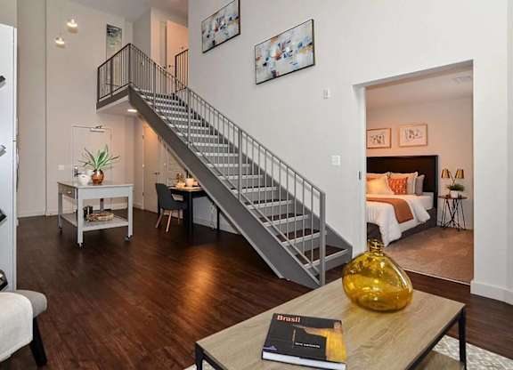A living room with a staircase and a book on the coffee table.