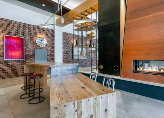 A modern bar area with a brick wall and a fireplace.
