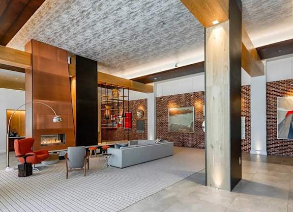 A modern living room with a fireplace and a grey sofa.