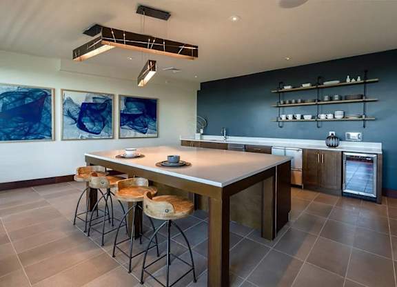 A kitchen with a table and chairs in front of it.