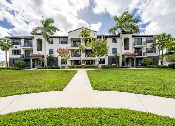 A large apartment complex with a walkway in front.