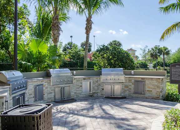 Outdoor kitchen with stone wall and grill.