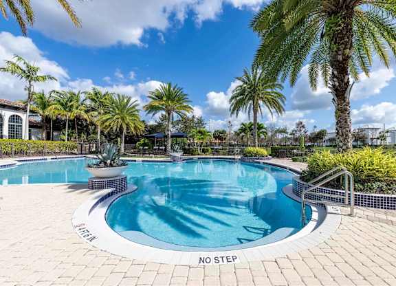 A pool surrounded by palm trees and a sign that says "No Step".
