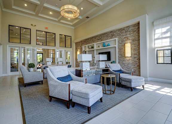 A living room with a grey rug and a white sofa.