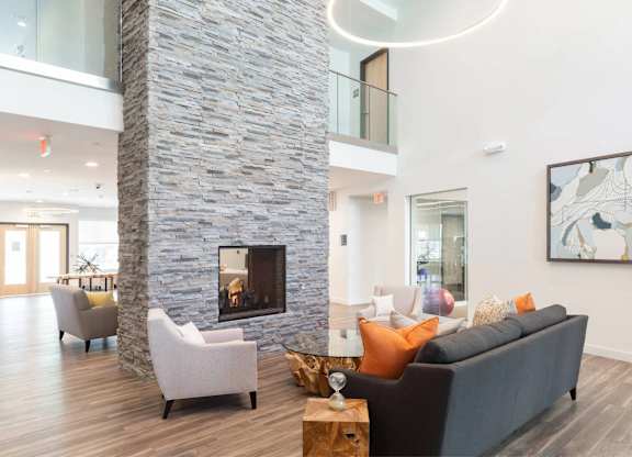 A modern living room with a stone pillar and a fireplace.