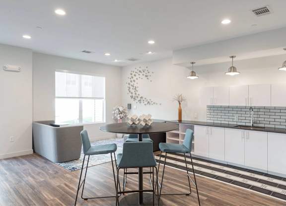 A modern kitchen with a dining table and chairs.
