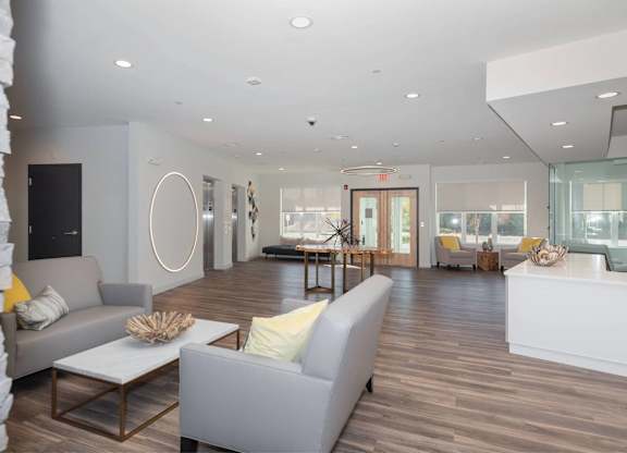 A spacious living room with a grey sofa and a white coffee table.