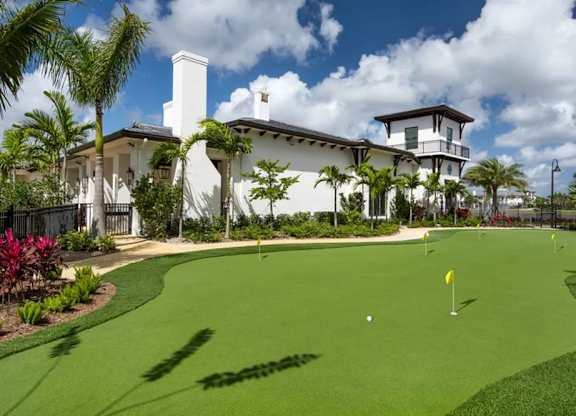 A golf course with a house in the background.