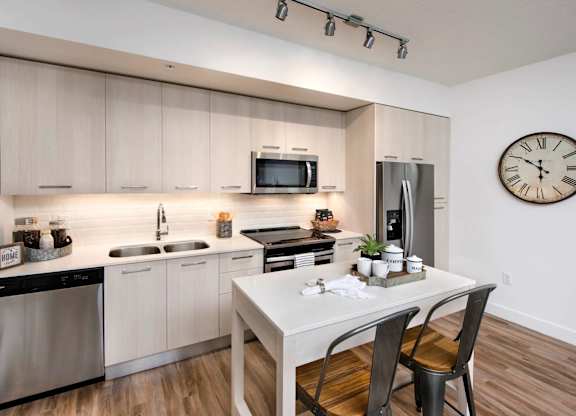 A modern kitchen with a white table and chairs.