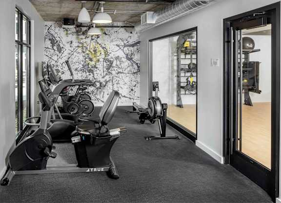 A gym with a row of exercise bikes and a wall with a map on it.