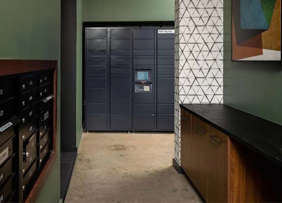A tall, dark blue metal storage unit with a digital keypad on the door stands in a room with a green wall and a wooden counter.