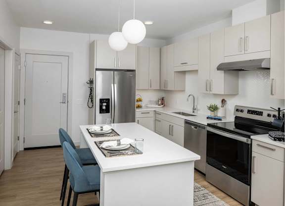 A modern kitchen with a dining table and chairs.