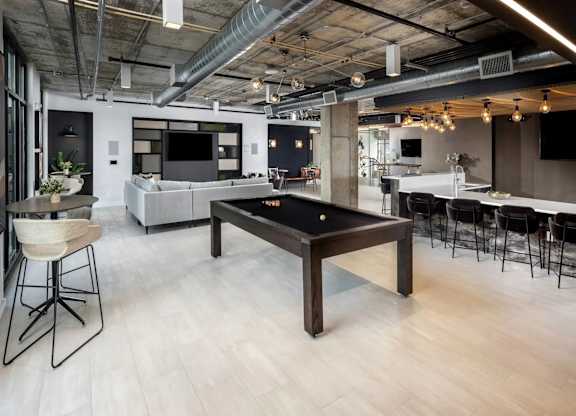 A modern open plan office with a pool table in the middle.
