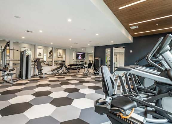 A gym with a treadmill, weights, and exercise equipment.