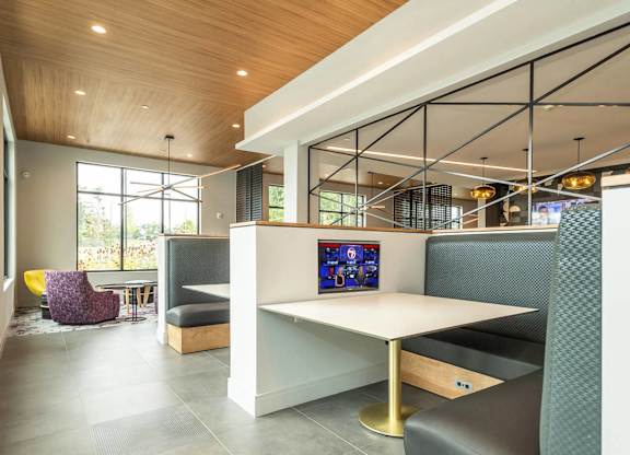 A modern lounge area with a white table and purple chairs.