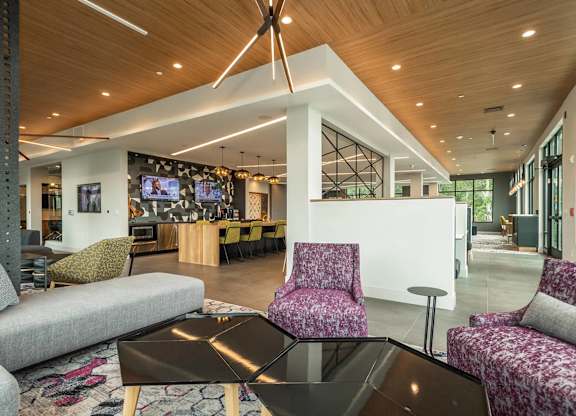 A modern living room with a black coffee table and a purple patterned chair.