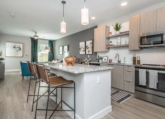A modern kitchen with a large island and bar stools.