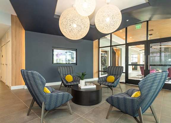Four chairs with yellow cushions are arranged around a table in a room.