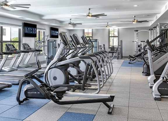 A gym with treadmills and elliptical machines.