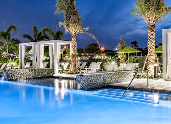A pool with a blue tiled edge and a white structure in the background.