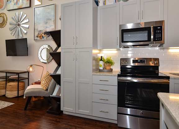 A modern kitchen with a stove, oven, and cabinets.