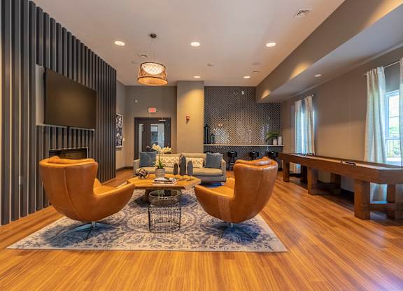 A modern living room with a striped wall and two yellow chairs.