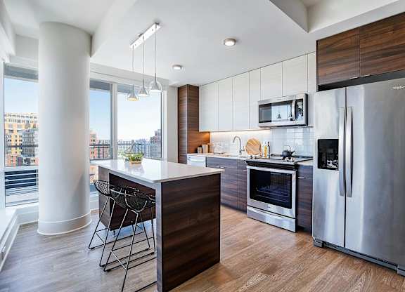 A modern kitchen with a wooden island and stainless steel appliances.