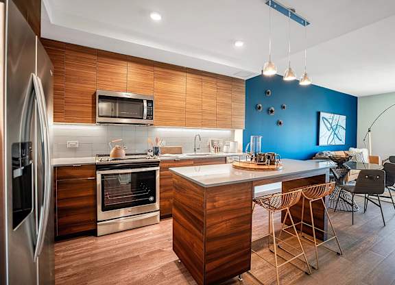 A modern kitchen with wooden cabinets and stainless steel appliances.