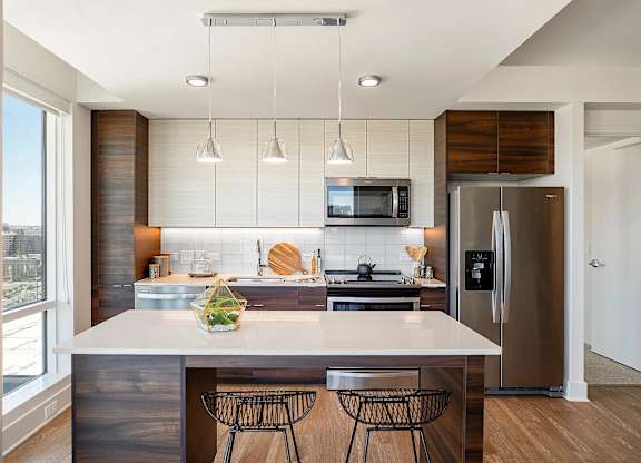 A modern kitchen with a large island and stainless steel appliances.