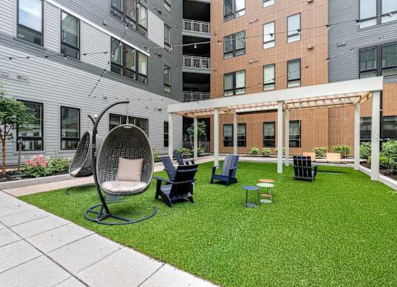 A patio with a white chair and a black table.