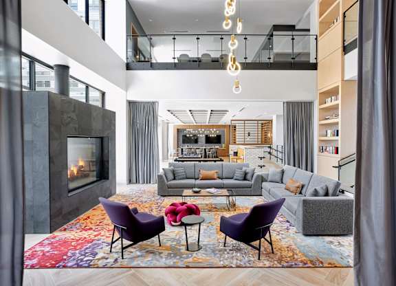 A modern living room with a fireplace and a large rug.