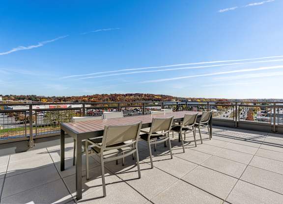 A table and chairs are set up on a patio overlooking a city.