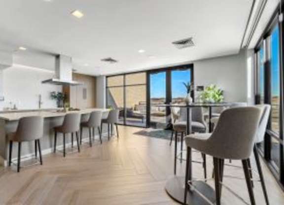 A modern kitchen with a bar area and chairs.