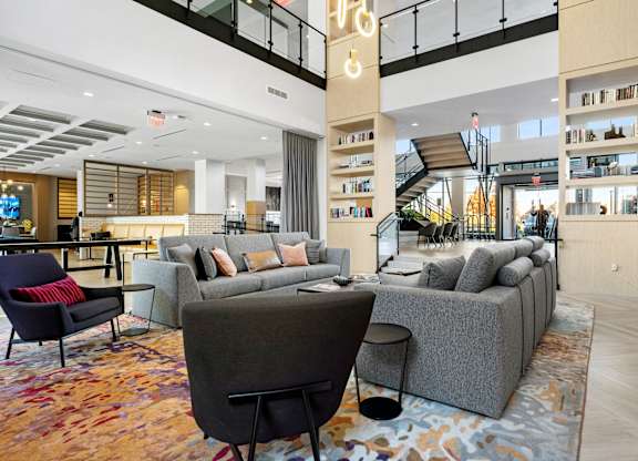 A living room with a grey couch and a red chair.