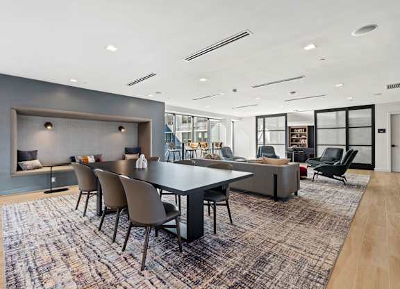 A modern dining room with a large table and chairs.