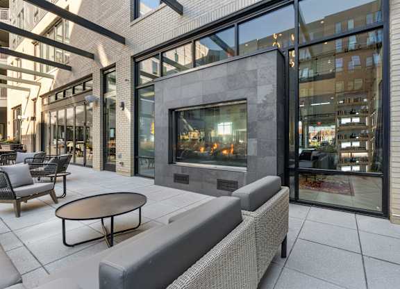 A modern outdoor seating area with a fireplace.