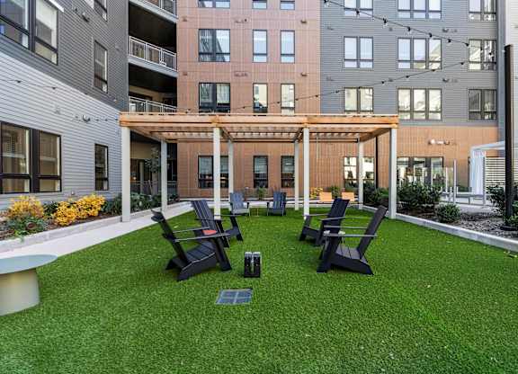 A patio with a table and chairs is surrounded by buildings.