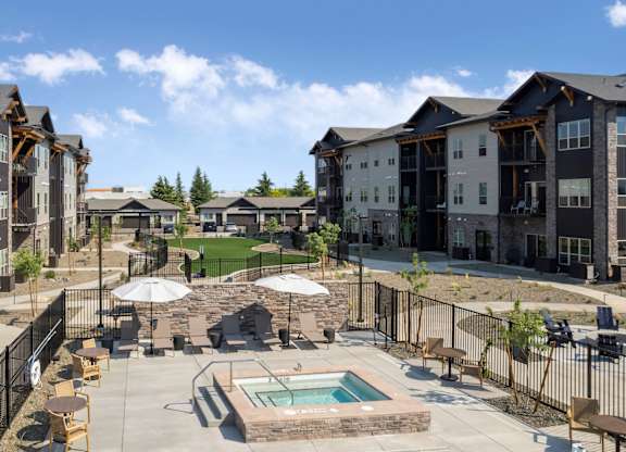 A large outdoor swimming pool surrounded by a fence and chairs.